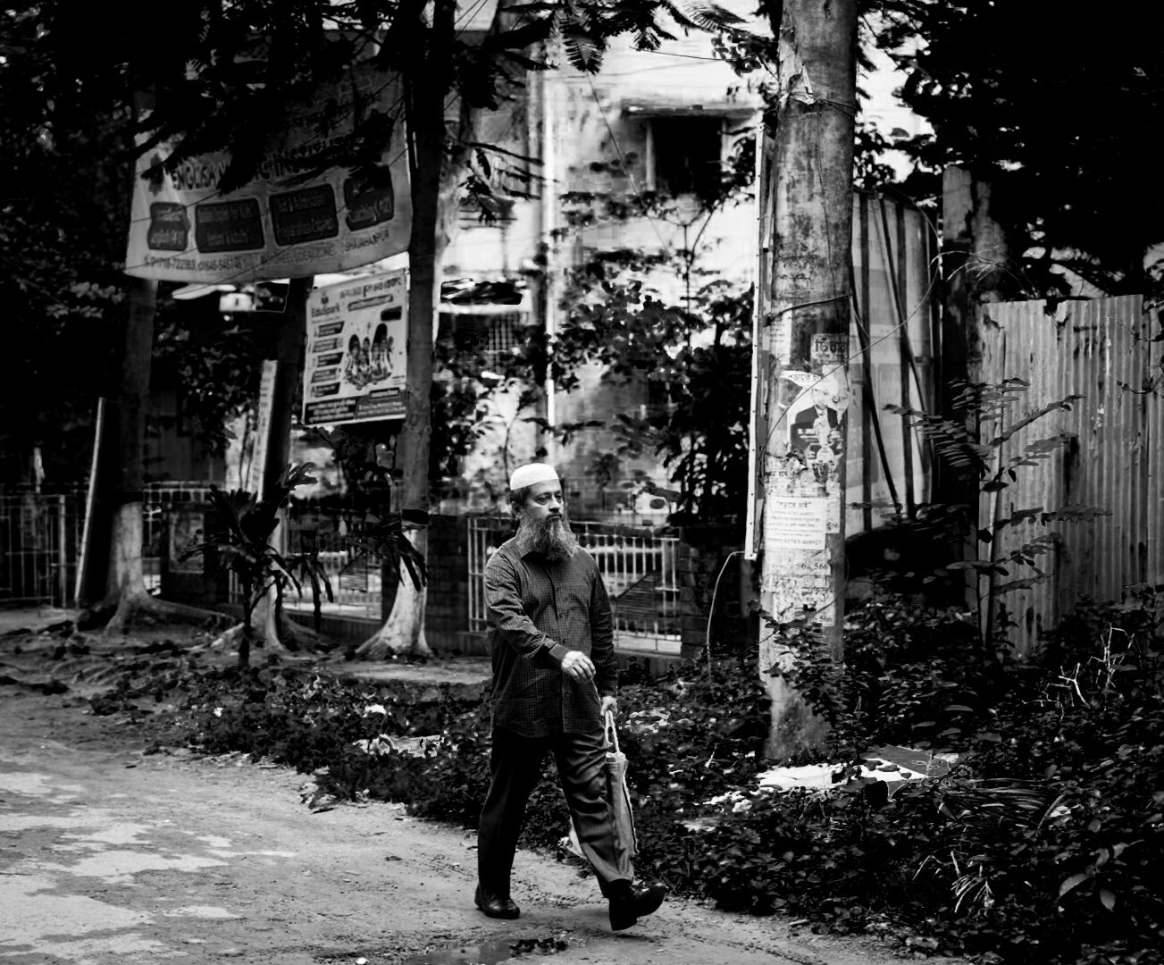 Man walking down a street carrying an umbrella