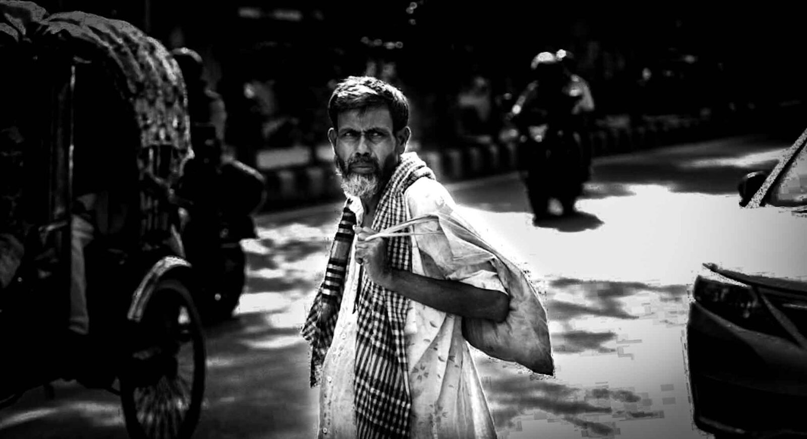 Man glancing back while walking past a rickshaw