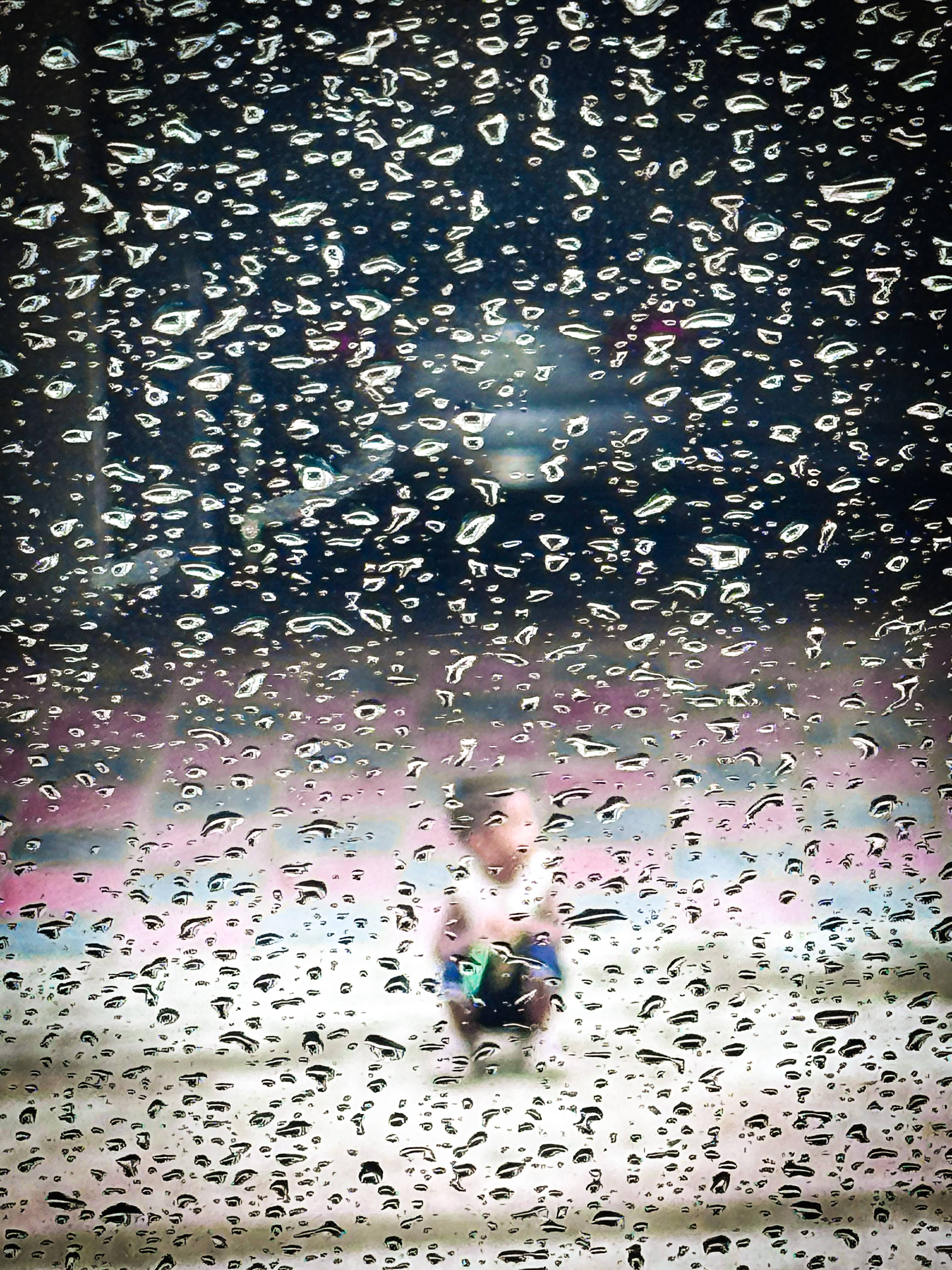 Football player seen through rain-covered glass
